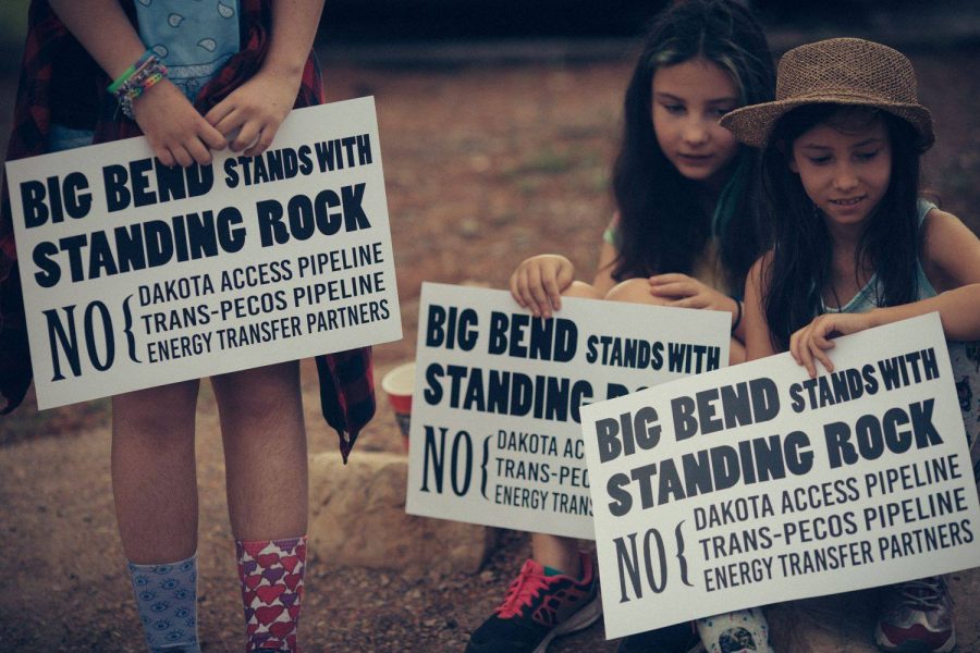 Young girls hold signs that draw connections between Trans-Pecos and the Dakota Access Pipeline. Photo courtesy of BBCA
