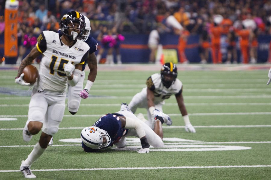 Southern Miss’s Ito Smith breaks a tackle while rushing around two UTSA defenders. Chase Otero/The Paisano
