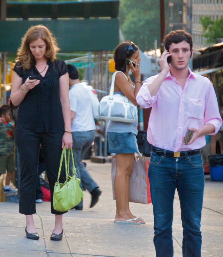People on their phones on a New York City street. Photo Courtesy of Creative Commons