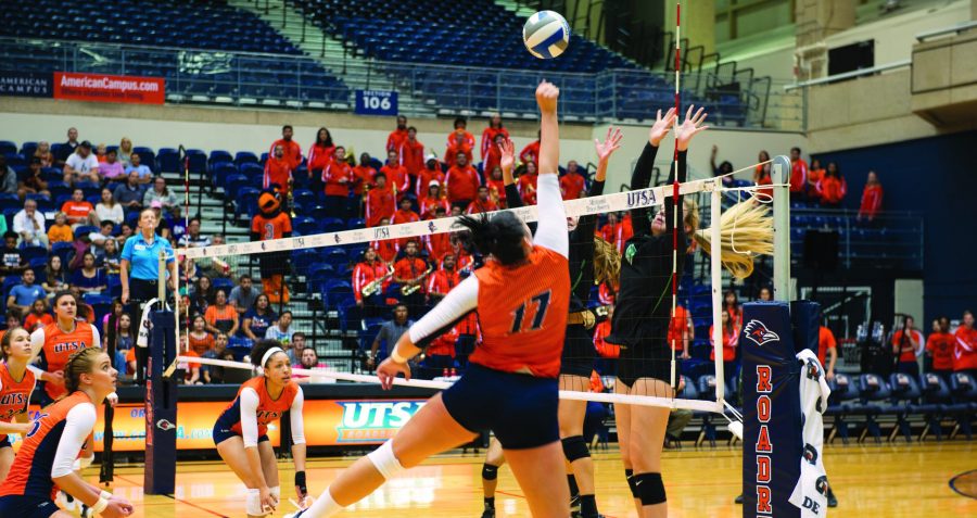 Volleyball player attempts to spike a ball.