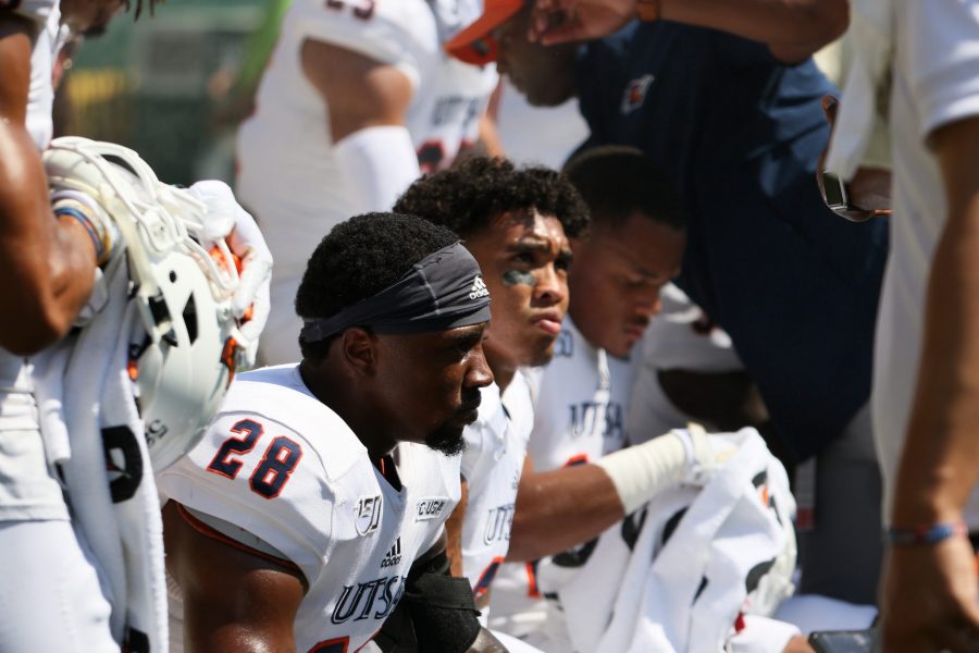 Cassius Grady listens in the sideline huddle. Photo by Lindsey Thomas