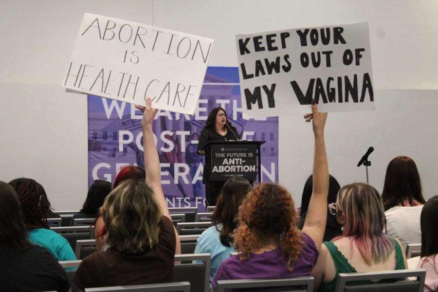 Students hold up pro-choice posters as a sign of protest as Kristan Hawkins delivers the speech.