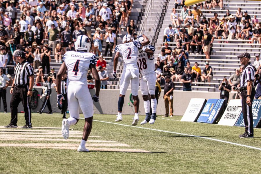 Zakhari Franklin, Joshua Cephus, and Trelon Smith celebrate in the endzone after a 1-yard touchdown run by Smith in the second quarter to tie the game 7-7.